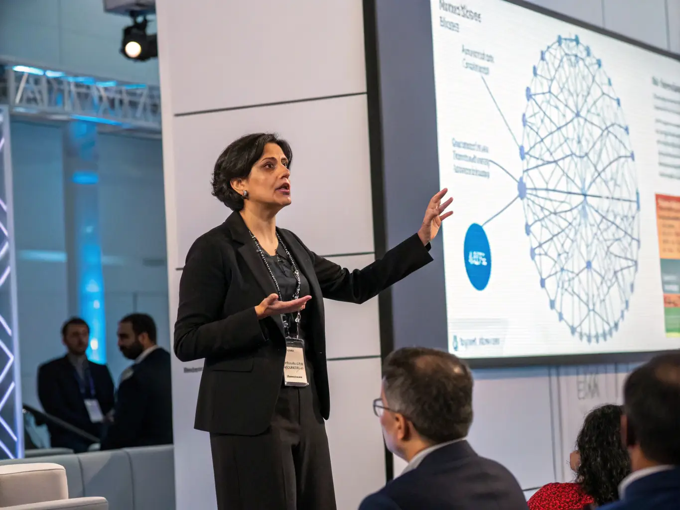 A professional headshot of Dr. Anya Sharma, a keynote speaker, smiling confidently against a blurred background of a tech conference stage. She is known for her work in AI ethics.